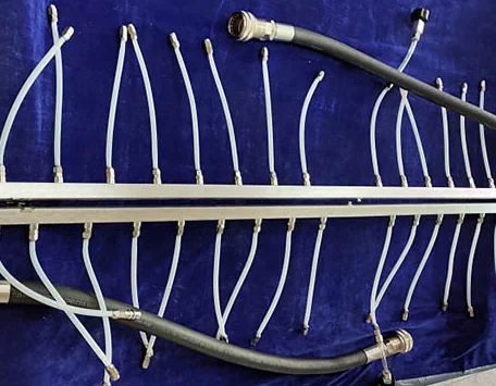 Two long rack liquid cooling manifold rails with many branch hoses and larger main supply or return connections